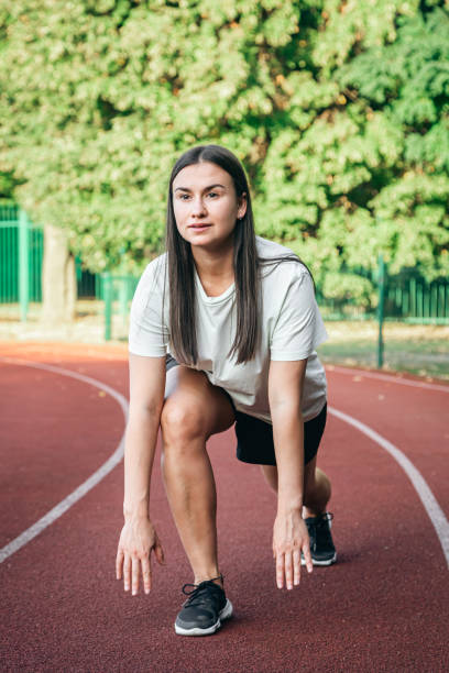 istock A young woman runner in start position on running track while work out. 1780072022