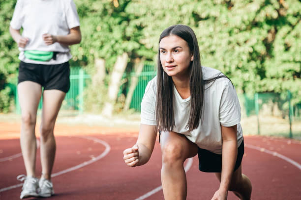 istock A young woman runner in start position on running track while work out. 1780072024