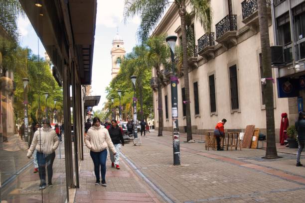 montevideo, uruguay - October 31 2022: person is walking on the shopping street in ciudad vieja during daytime with reflection in shop window