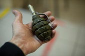 Hand holding grenade. There are explosives in palm of person's hand. Munitions.