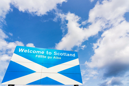 A large Welcome to Scotland sign Scotland/England border on the A1 on a bright, sunny day.