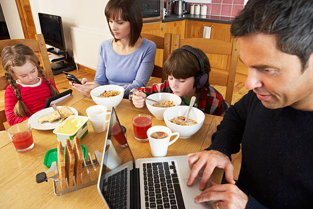 istock Family Using Gadgets Whilst Eating Breakfast Together In Kitchen 178013733