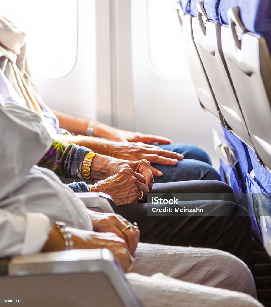 Mano de una mujer de edad avanzada en la butaca de los aviones - Foto de stock de Avión libre de derechos