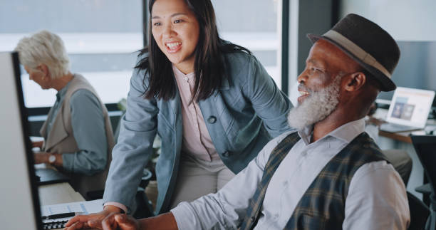 istock Business people, manager and employee with computer, coaching and cooperation with teamwork, support and advice. Black man, Asian woman and staff with technology, help and talking with communication 1780145263
