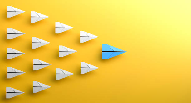 Leadership concept, blue leader plane leading white planes, on yellow background with empty copy space on right side stock photo
