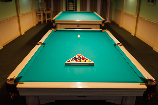 Billiard accessories balls and cue on a billiard table room