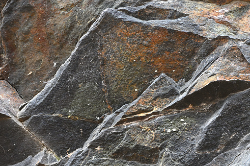 Rock outcrop of jagged schist, close-up -- showing the characteristic layers of this metamorphic rock having split into irregular plates. This formation is on the east slope of Mount Tom in northwest Connecticut, where the rocks are estimated to be 1.3 billion years old. The bedrock in this area is known as Ratlum Mountain schist, which is similar to the Manhattan schist found in New York City's Central Park.