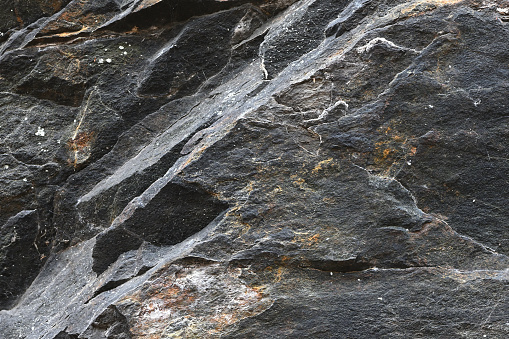 Close-up of schist rock face -- showing the characteristic layers of this metamorphic rock having split into irregular plates. This formation is on the east slope of Mount Tom in northwest Connecticut, where the rocks are estimated to be 1.3 billion years old. The bedrock in this area is known as Ratlum Mountain schist, which is similar to the Manhattan schist found in New York City's Central Park.