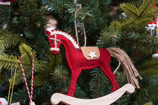 a wooden red horse toy on a Christmas tree, New Year card