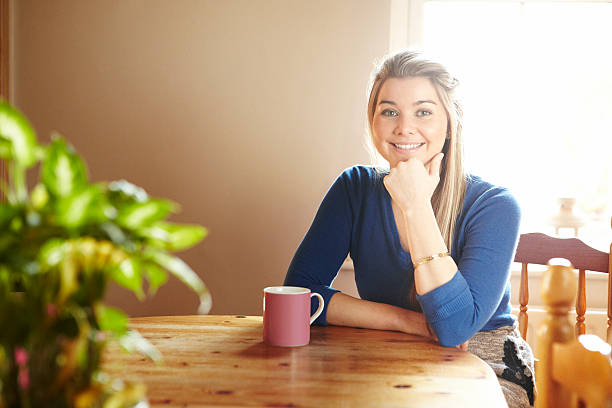 istock Young woman sitting at table smiling 178018358