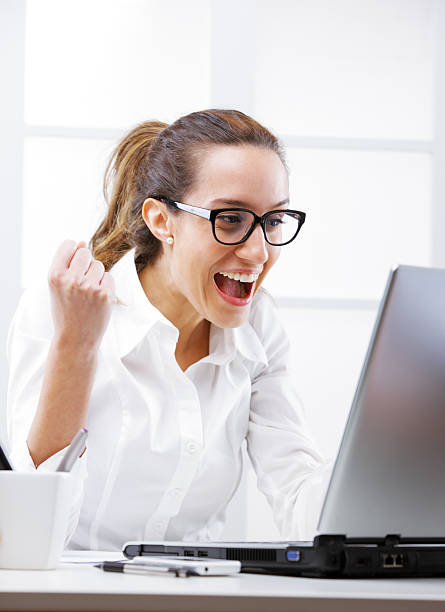 istock Victory - Young business woman using a laptop at work 178018692