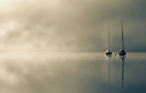 Sailboats in the morning-mist at the Ammersee in bavaria