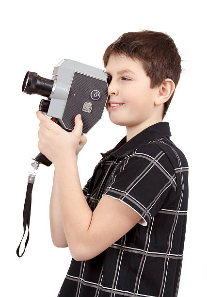 istock young boy with old vintage analog 8mm camera 178018975