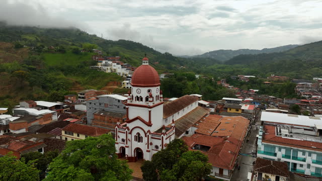Aerial view rising in front of the St Raphael's Church in cloudy Antioquia, Colombia