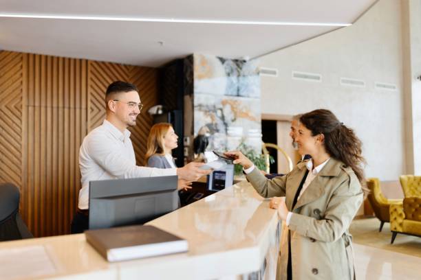 istock Woman paying something with her smartphone at the hotel reception 1780197549