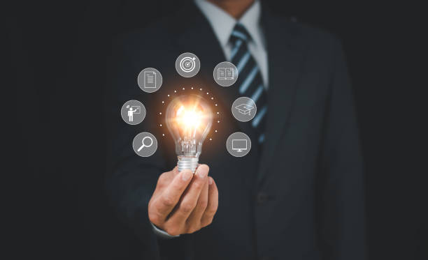 istock Businessman holding glowing lightbulb with learning icons for study knowledge to creative thinking idea and problem solving solution concept. 1780219400