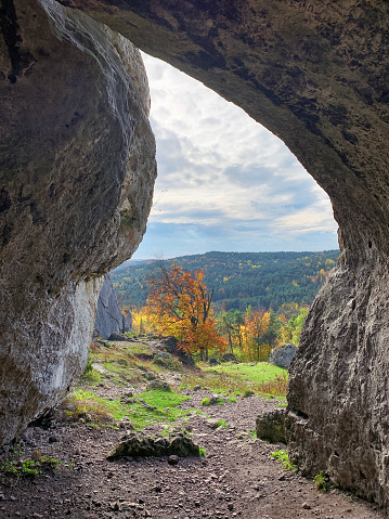 Cave in Chalk rock landscape of Polish Jurassic Highland  near by krakow in south–central Poland. View out of a cave at atumn time landscape