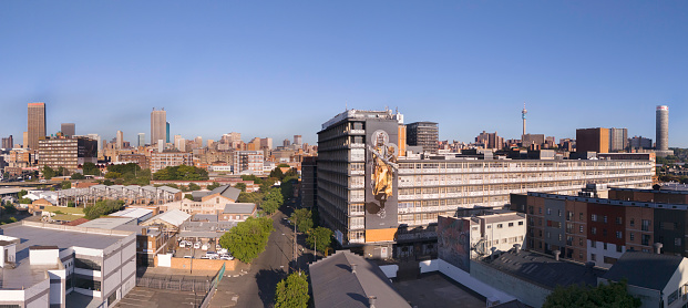 Johannesburg city with the prominent Transnet building in the Carlton Centre, Ponte City apartments and Telkom Communications tower, seen from Doornfontein with a large mural.