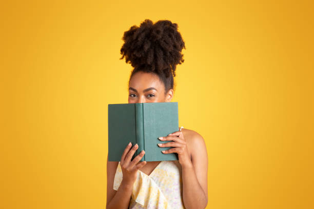 istock Cheerful young black woman reading book, has fun alone 1780243611