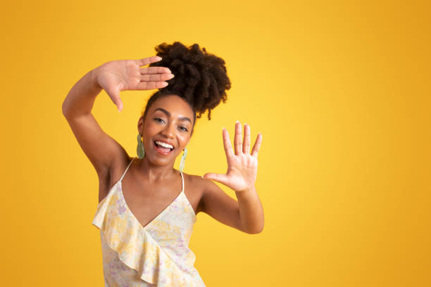 istock Smiling millennial black lady in dress making frame, lens sign with hands 1780243628
