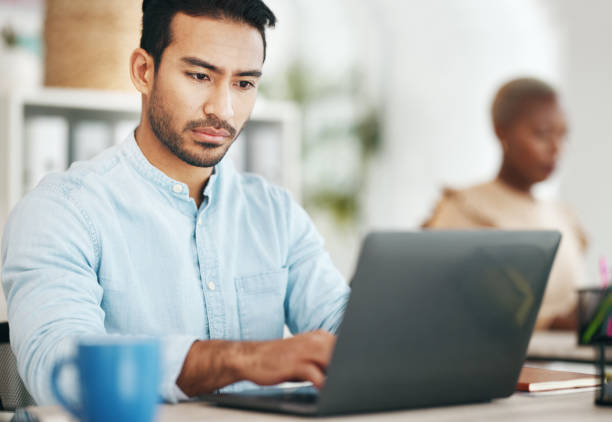 istock Asian man, laptop and typing in startup office for planning, schedule or proposal in workplace. Web design expert, computer and focus at desktop for development, goals and seo strategy on internet 1780244768