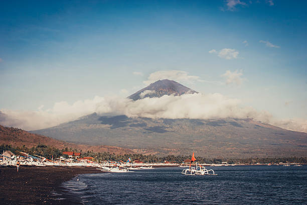 BALINÉS tradicionales barcos de pesca y volvano con nubes - foto de stock