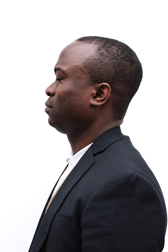Well-dressed man is captured in profile against a clean, white background