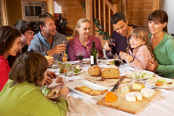 due famiglie godendo pasto insieme in stile chalet di montagna - skiing ski family friendship foto e immagini stock