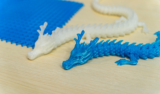 3D printer printing dragon head figure close-up.