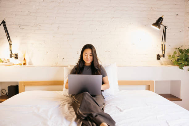 istock Young woman using a laptop on bed 1780279874
