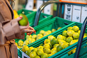 Woman choosing tangerines while shopping in super market