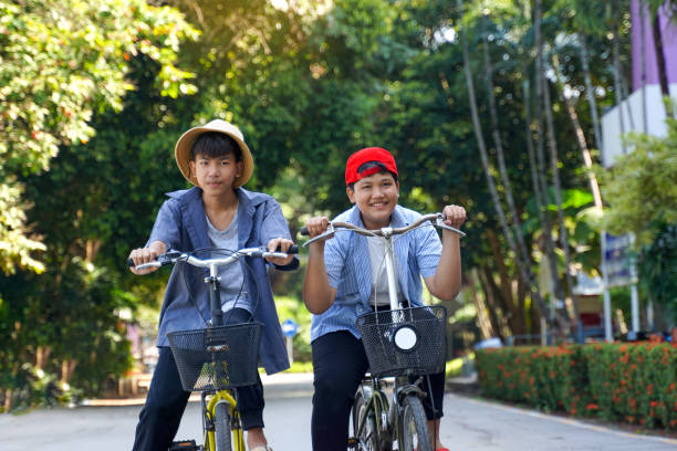 istock Two Asian boys  ride bicycles in the  park 1780299697