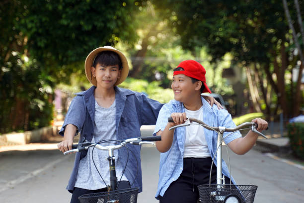istock Two Asian boys  ride bicycles in the  park 1780299722