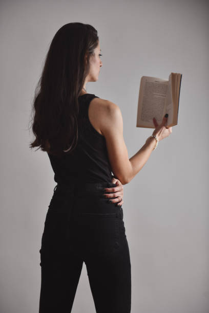 istock Rear View Of Female Reading A Book On Grey Background 1780314546