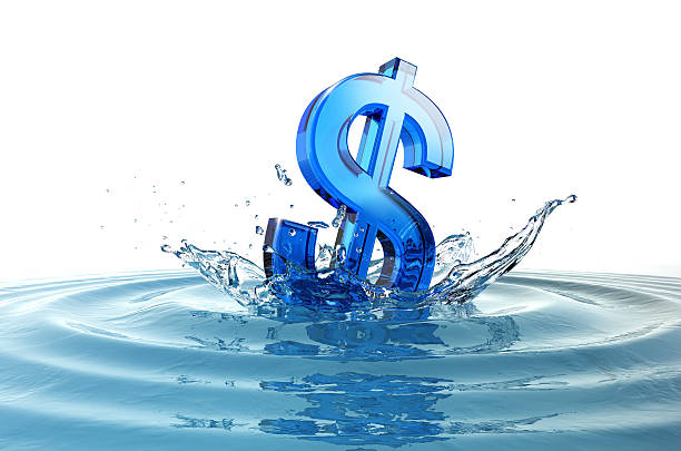 US dollar sign falling into water with splash. stock photo