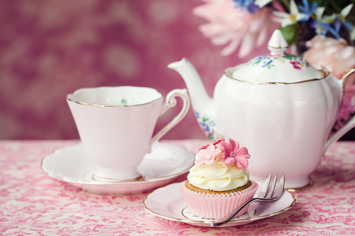 A cup of hot tea served in an ornate patterned cup and saucer - studio shot.