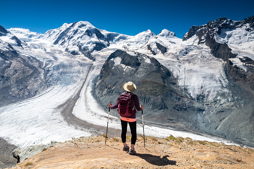 Switzerland Travel - Rear view of woman hiking the mountains near Gorner Glacier