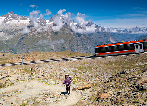 Switzerland travel - Senior woman hiking a trail near the Gornergrat train in the Swiss Alps