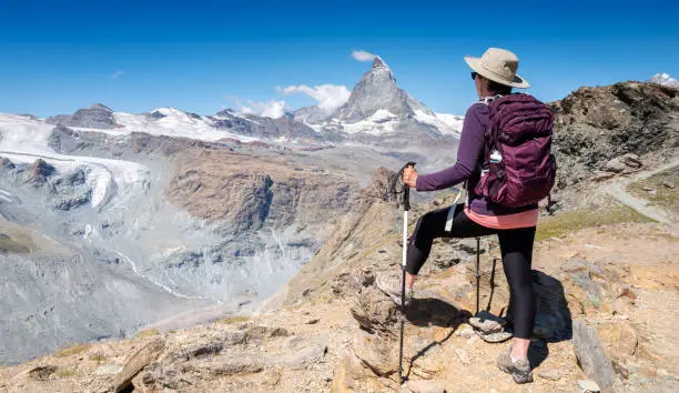 Switzerland Travel - Rear view of woman hiking the mountains near the Matterhorn in Zermatt