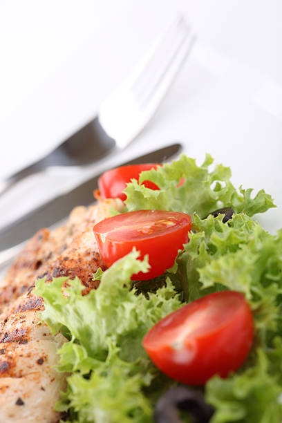 Grilled chicken breasts on a plate with fresh vegetables stock photo