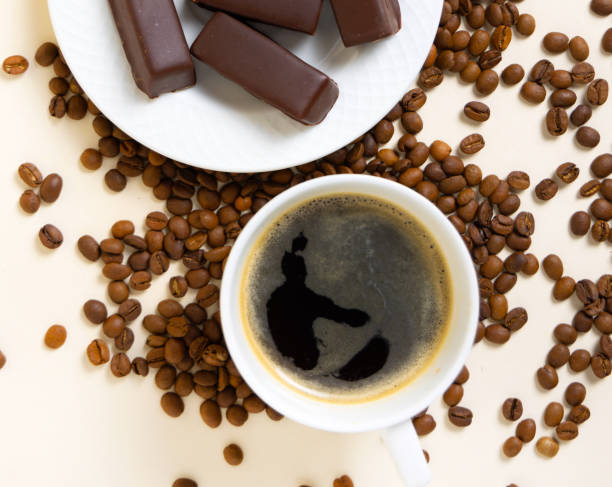 bird's milk,polish soft chocolate covered,candy filled with soft meringue,strawberry or coffee taste,red color.coffee beans and box with sweets,cup with americano.product photography,top view