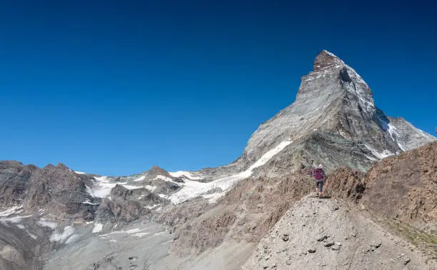 Switzerland Travel - Woman hiking trail to the base of the Matterhorn in the Swiss alps