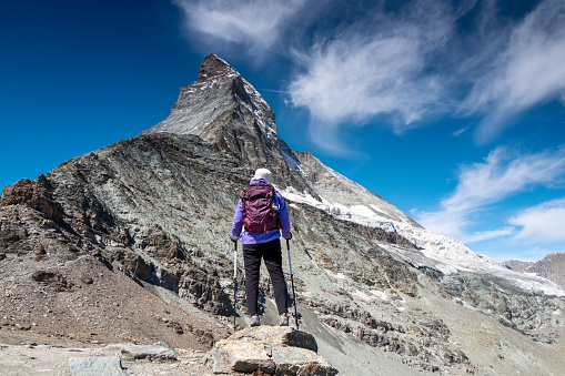 Switzerland travel - rear view of mature woman hiking the Matterhorn near Zermatt, Switzerland in early summer