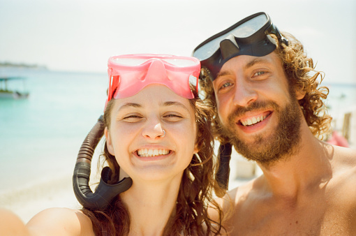 Selfie of man and woman in snorkelling masks on beach holiday  shot on camera film