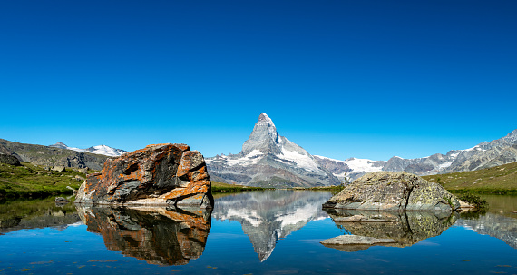 Switzerland Travel - Stellisee on a clear sky summer day with a view of the Matterhorn in the Swiss Alps.