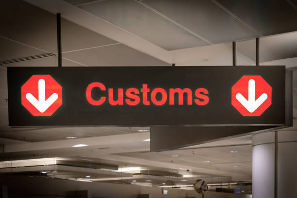 Customs sign in Airport and direction arrow, red and lighted. Travel, tourism, trade concept