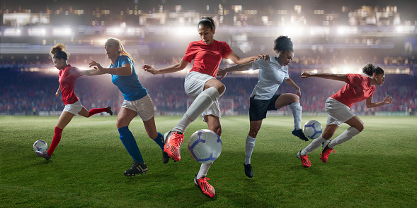 A montage of five female footballers in various action poses playing soccer on a football pitch in a floodlit stadium. The soccer players wear generic kit in red, white and blue colours.