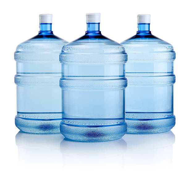 Three blue water cooler bottles isolated on white Three big bottles of water isolated on a white background gallon stock pictures, royalty-free photos & images