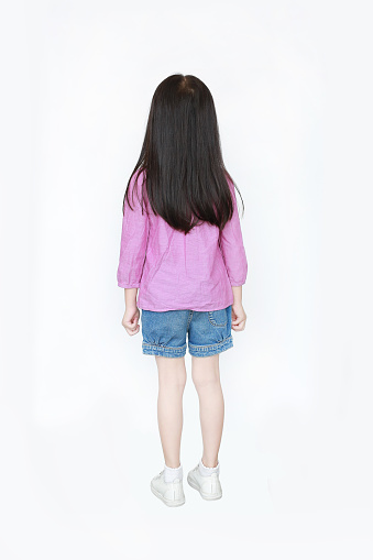 Rear view little Asian child girl standing with long hair isolated over white background.