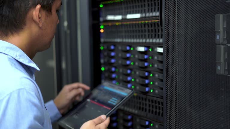 System administrator working with tablet to check server and equipment  in data center.